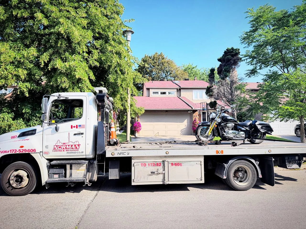 Norman Towing flatbed tow truck transporting a motorcycle in the Greater Toronto Area