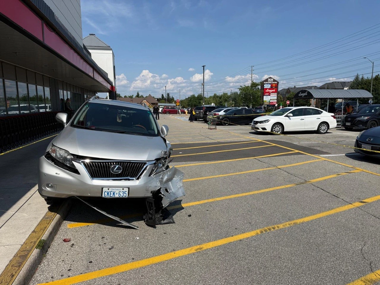 Lexus SUV with front-end collision damage in a parking plaza.