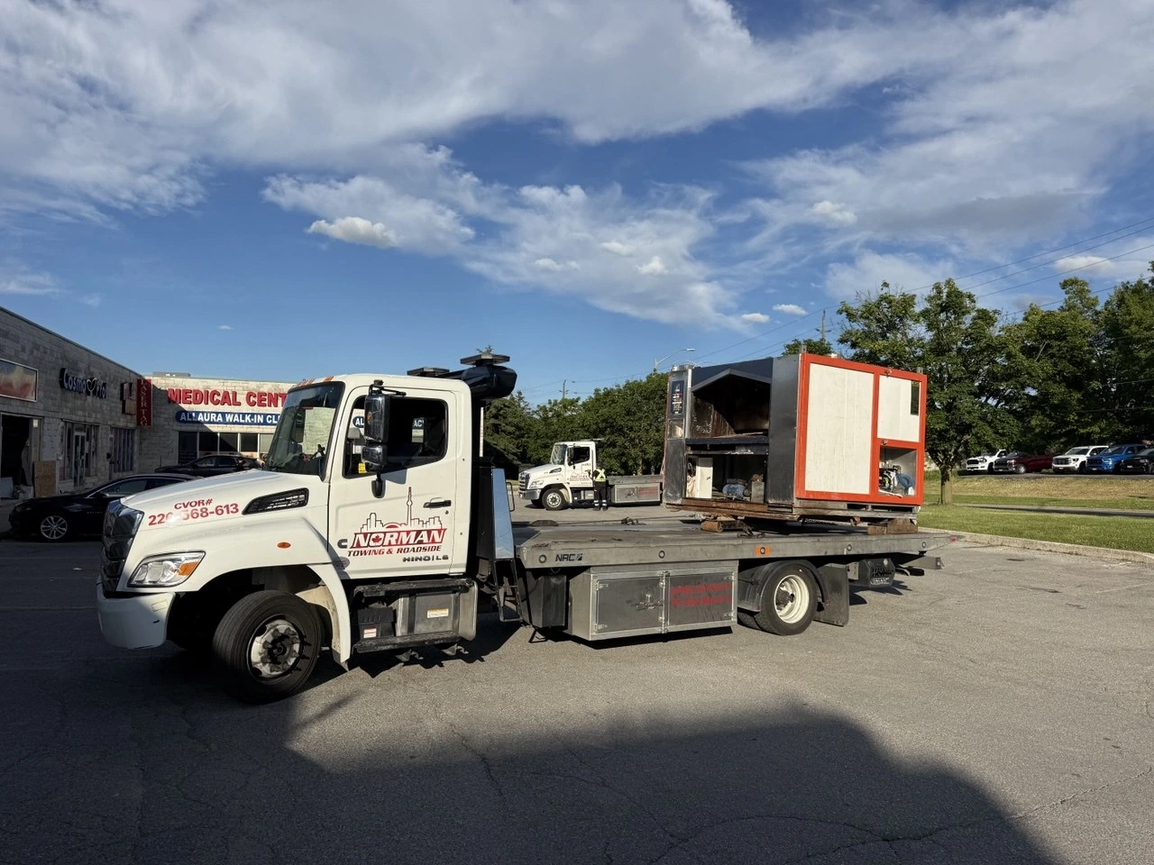 Large industrial equipment crate carried on a Norman Towing flatbed.