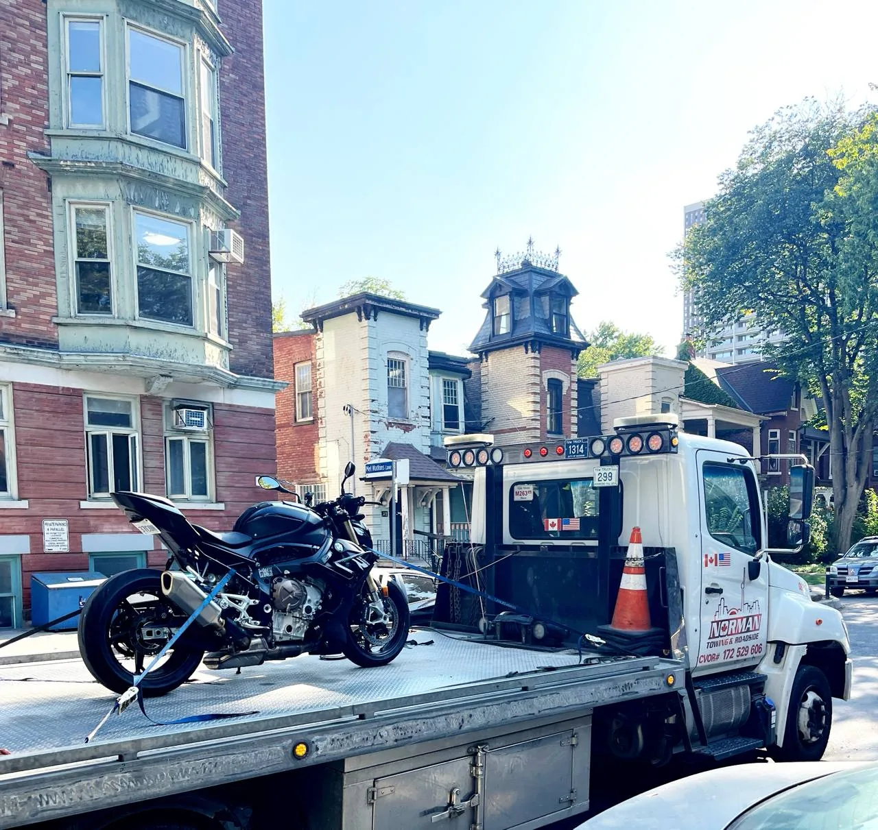 Motorcycle on a Norman Towing flatbed on a downtown Toronto street