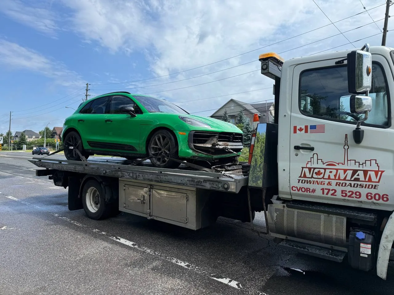 Green Porsche Taycan secured on a Norman Towing flatbed.
