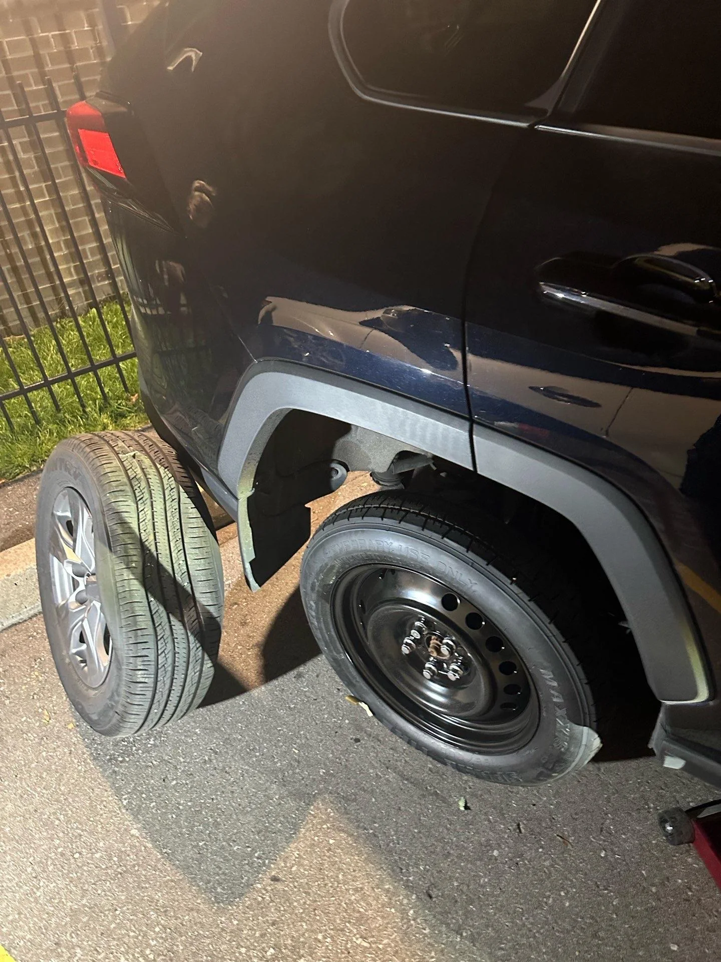 Spare wheel installed on an SUV during roadside flat tire service