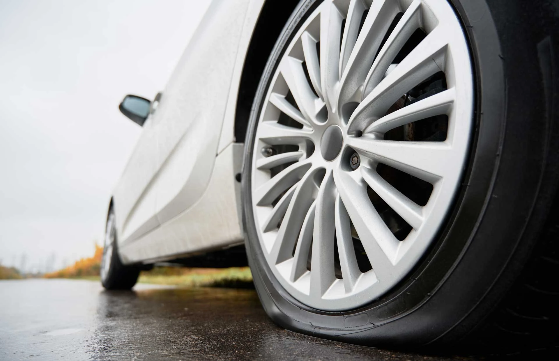 Close-up of a flat tire on a parked car.