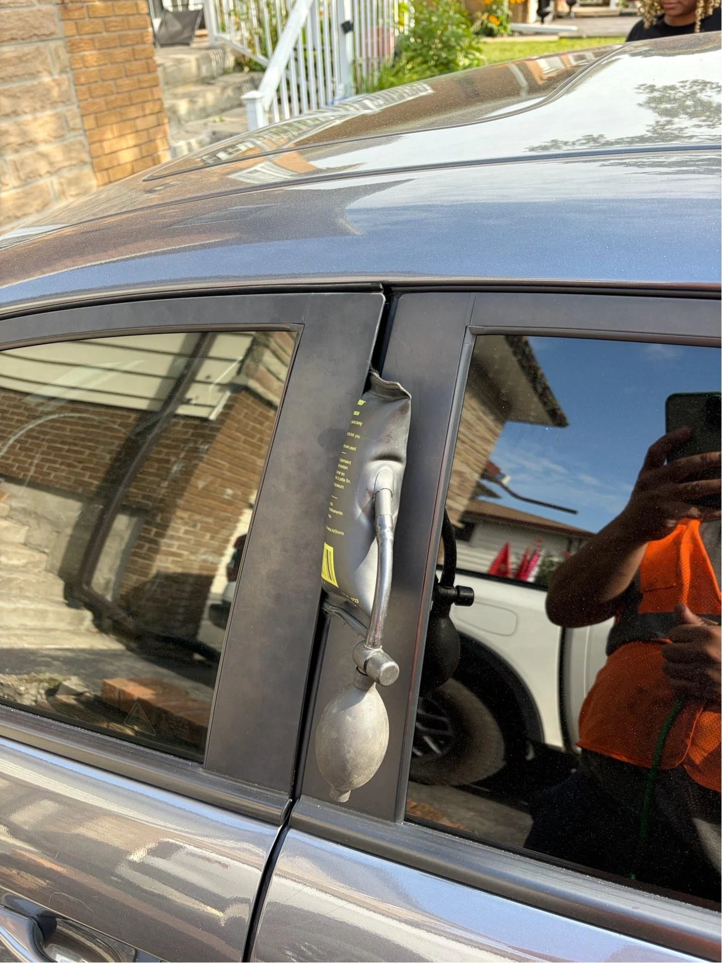 Vehicle Lockout Assistance | Norman Towing Air wedge lockout tool inserted into a car door frame during vehicle lockout assistance.