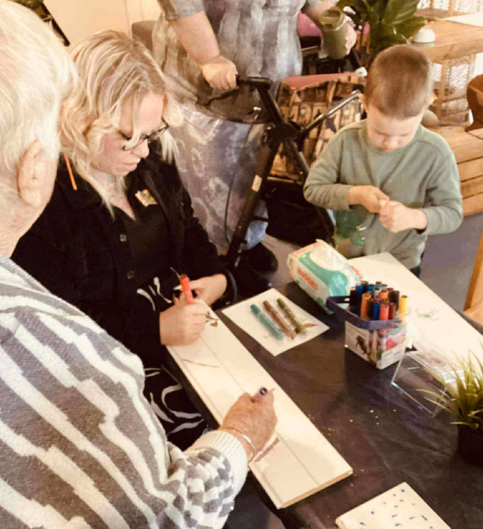 Adults and children at a daycare participating in an art and yarn workshop