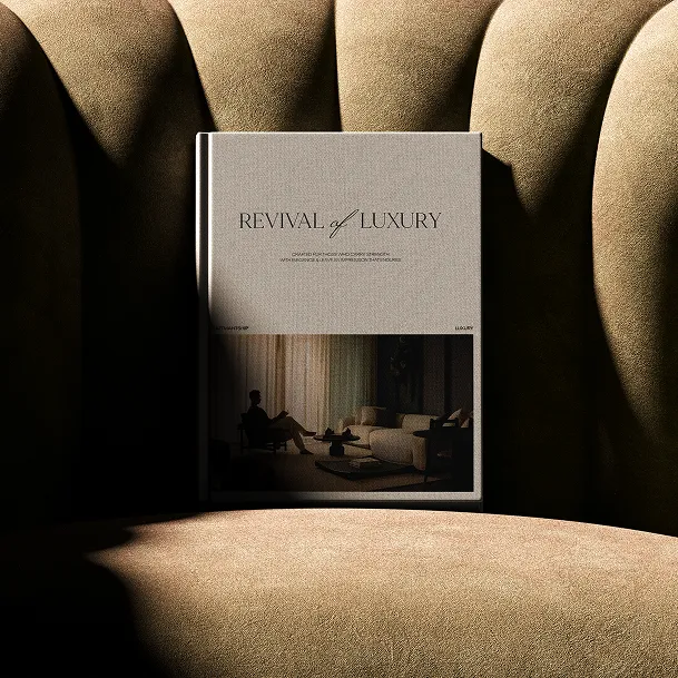 Book titled 'Revival of Luxury' resting on a plush, textured beige chair under dramatic lighting.