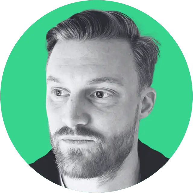 Portrait of a bearded man with short hair looking slightly to the left against a green circular background.
