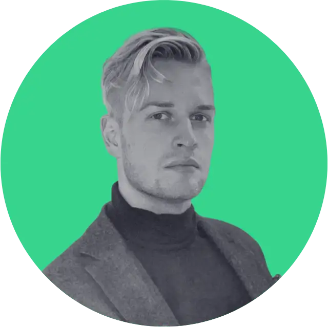 Portrait of a serious young man with blond hair wearing a dark turtleneck and blazer on a green background.