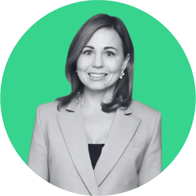 Smiling woman wearing a blazer with shoulder-length hair on a green circular background.