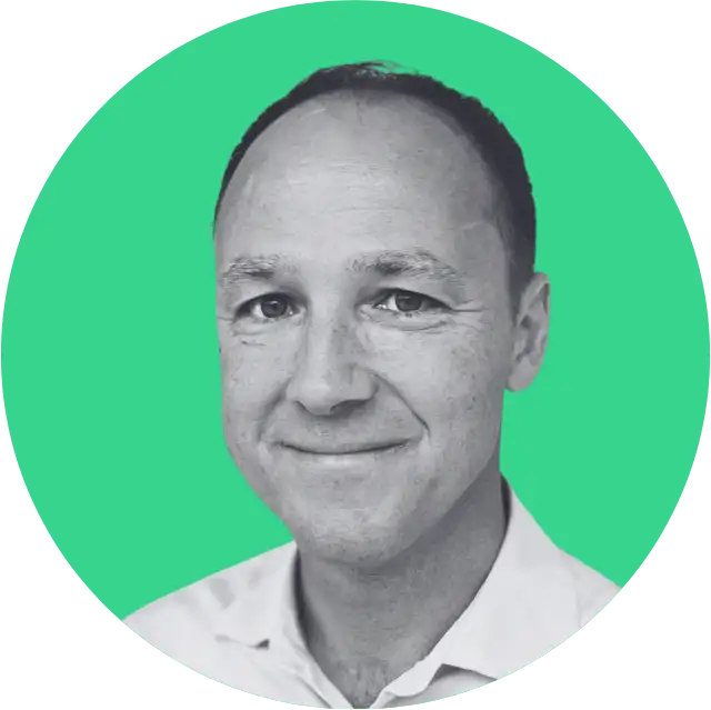 Black and white headshot of a smiling man against a solid green circular background.
