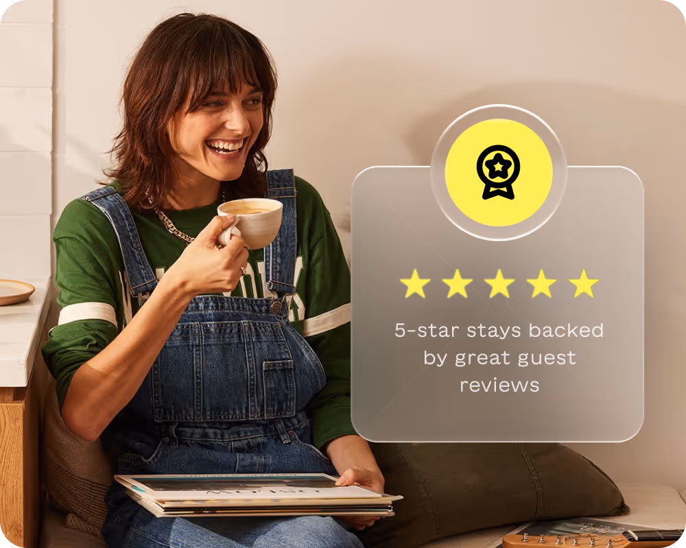 Smiling woman in green shirt and denim overalls drinking coffee and holding vinyl records next to a graphic of five gold stars and text about 5-star stays with great guest reviews.