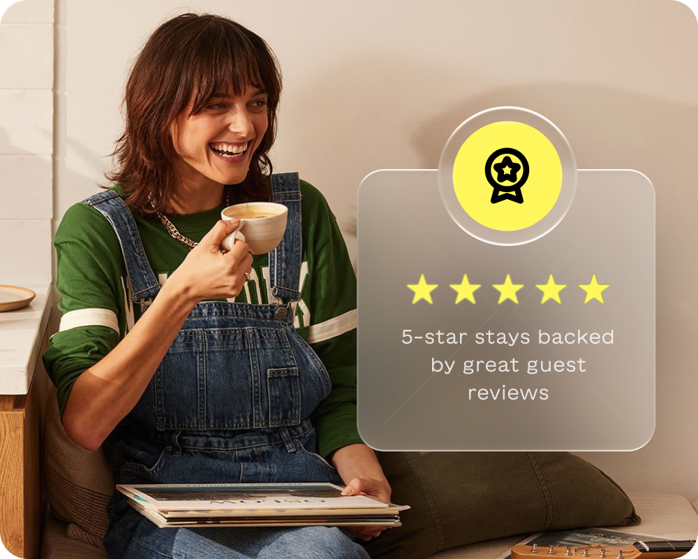 Smiling woman in green shirt and denim overalls drinking coffee and holding vinyl records next to a graphic of five gold stars and text about 5-star stays with great guest reviews.