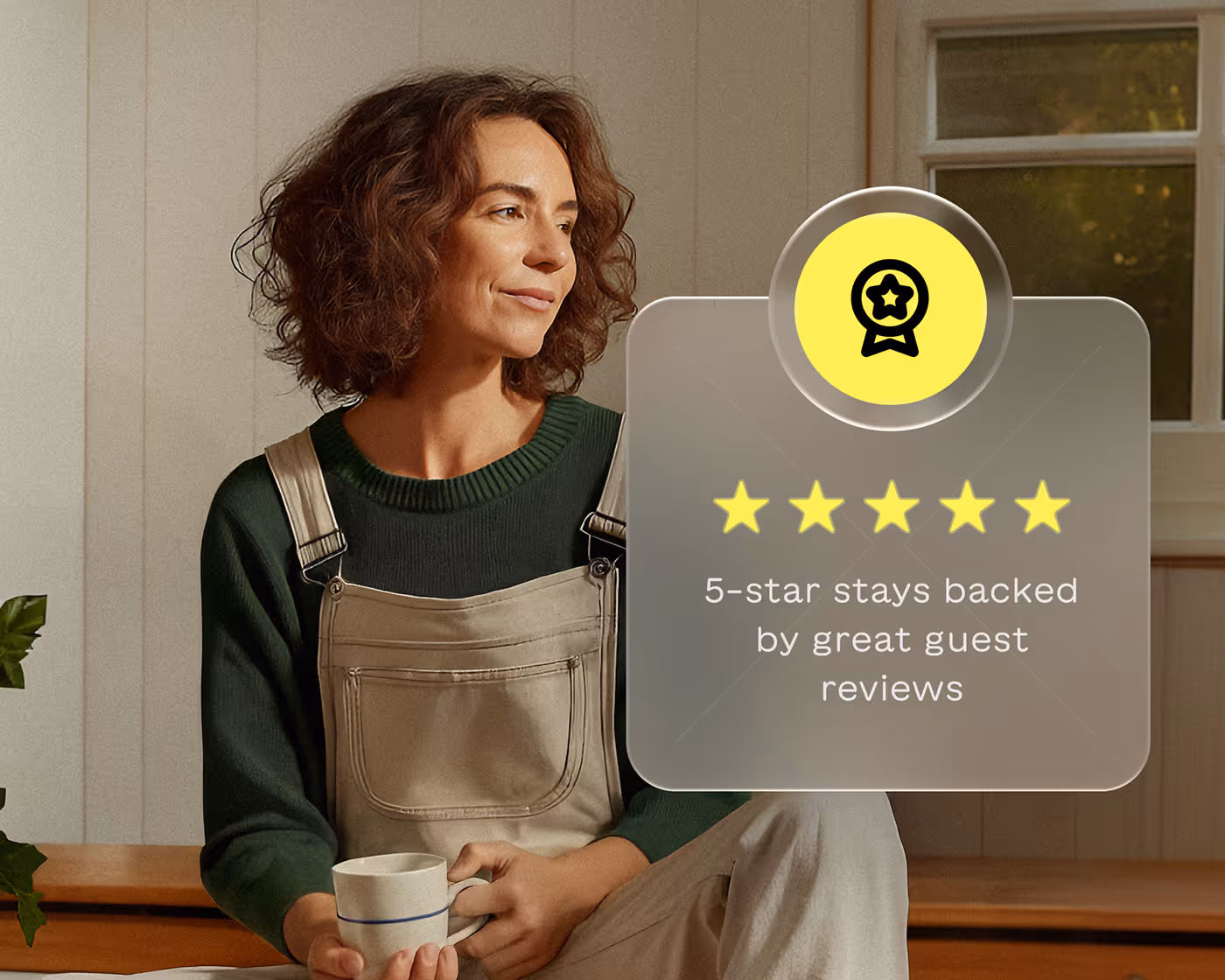 Woman with curly hair wearing green sweater and beige overalls holding a white cup, next to a graphic showing five yellow stars and text reading '5-star stays backed by great guest reviews'.