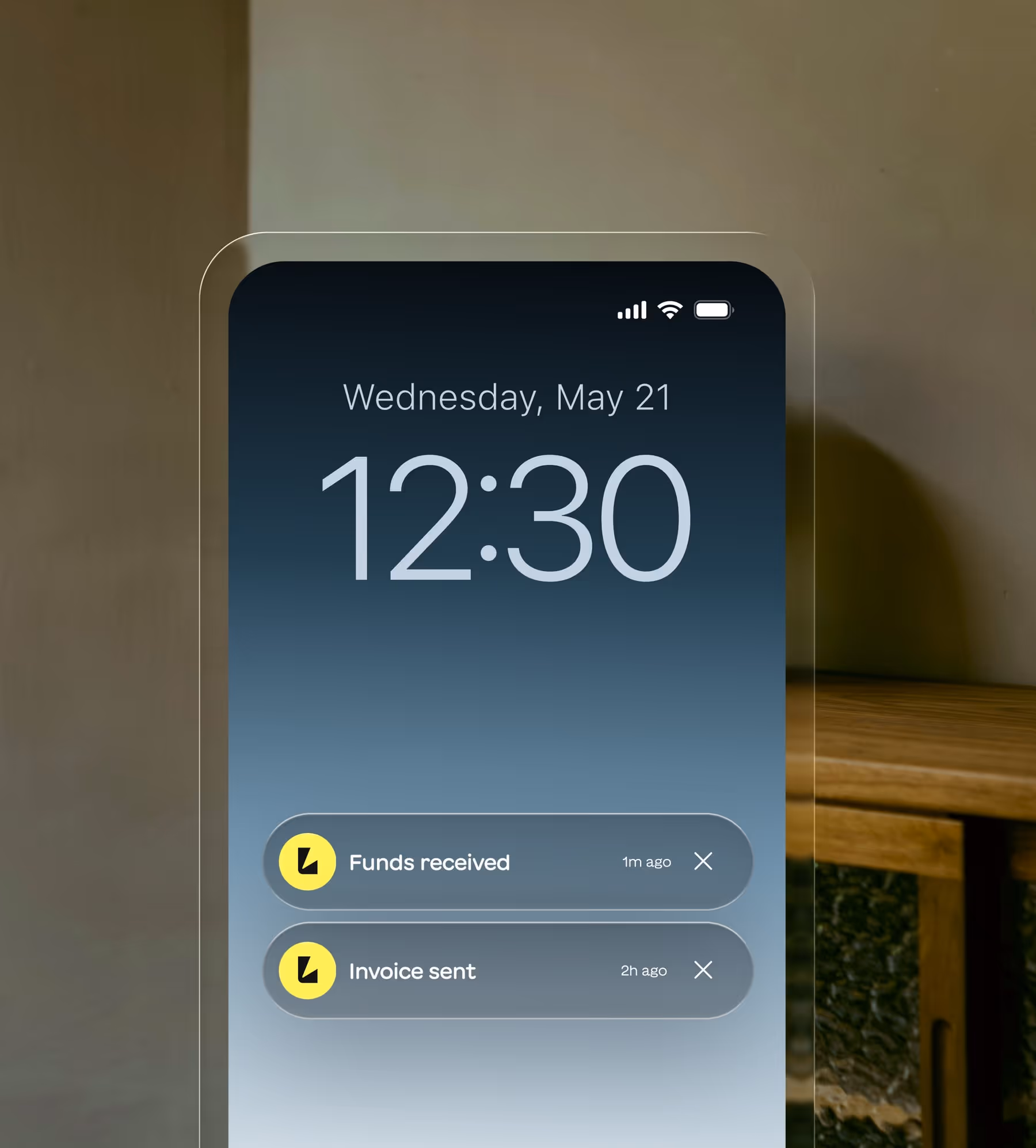 Phone lock screen showing date Wednesday, May 21, time 12:30, with notifications for 'Funds received' 1 minute ago and 'Invoice sent' 2 hours ago.