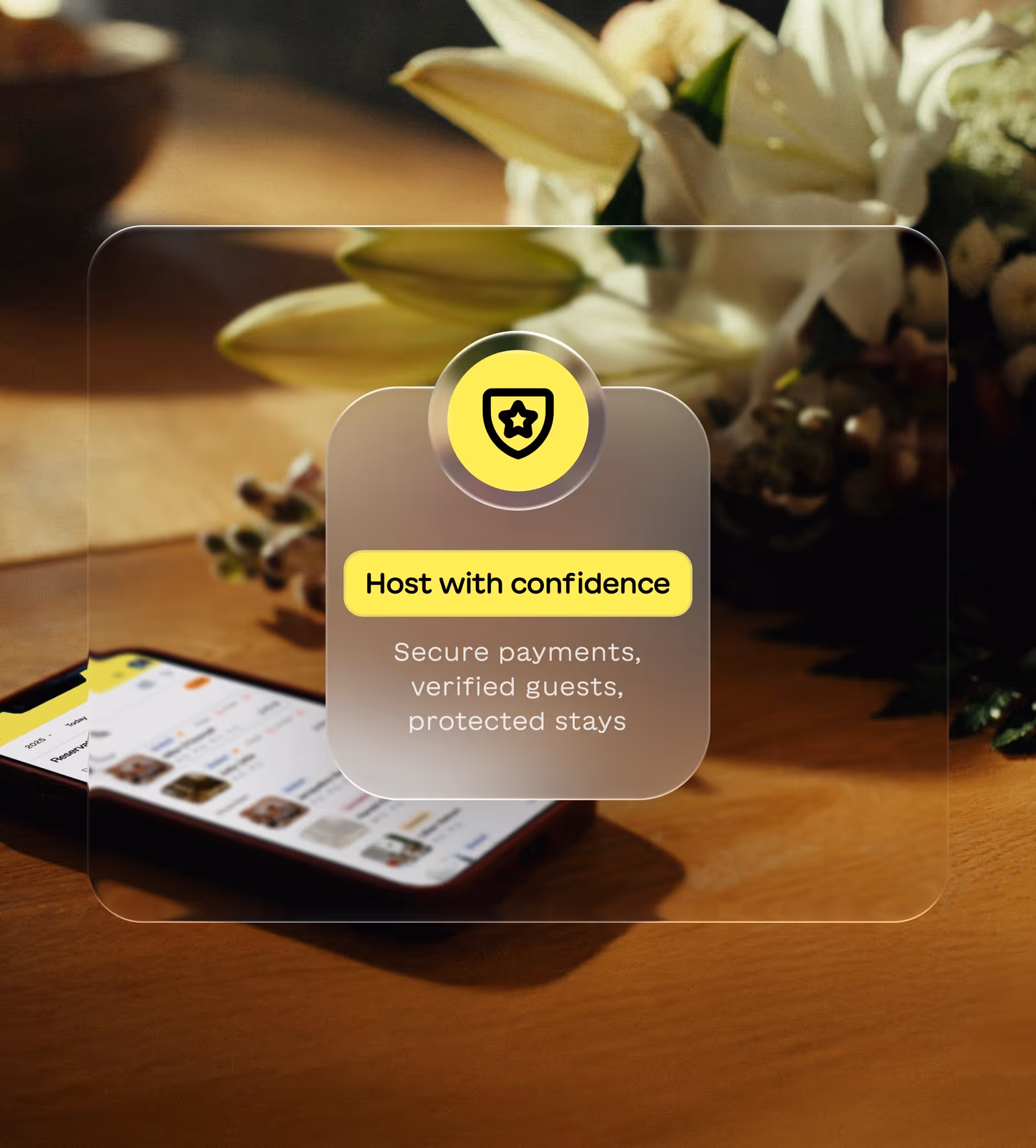Smartphone on wooden surface showing app interface with overlay text: Host with confidence, secure payments, verified guests, protected stays.