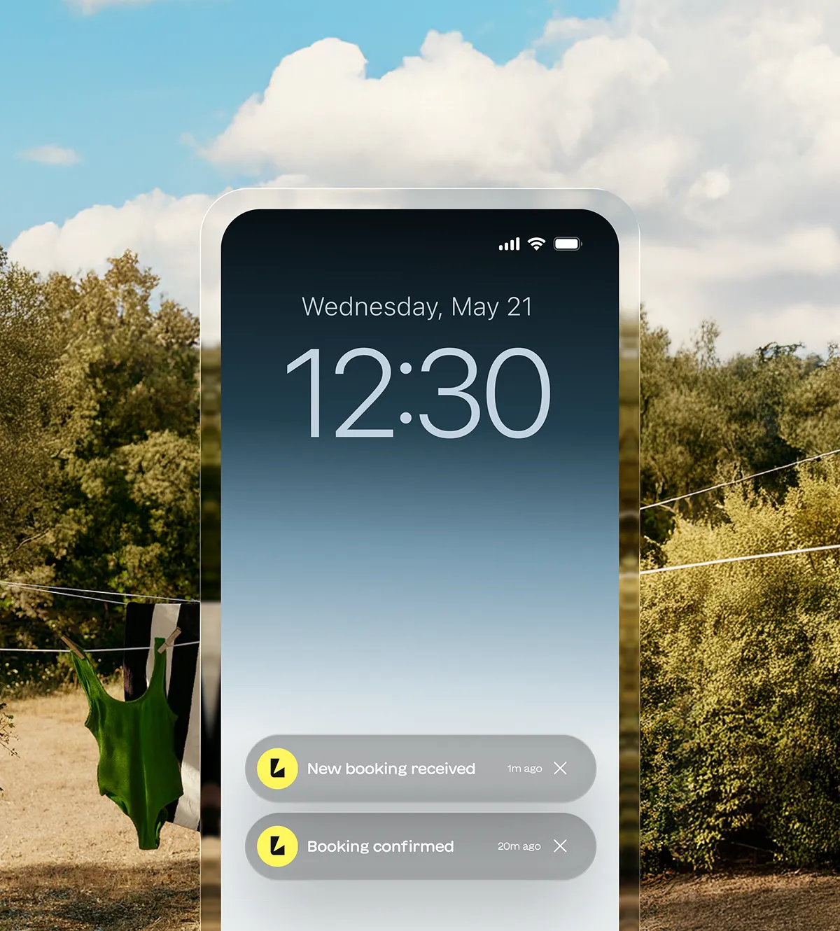 Smartphone lock screen showing time 12:30 on Wednesday, May 21 with notifications of new booking received and booking confirmed, set against an outdoor background with clothes hanging on a line.