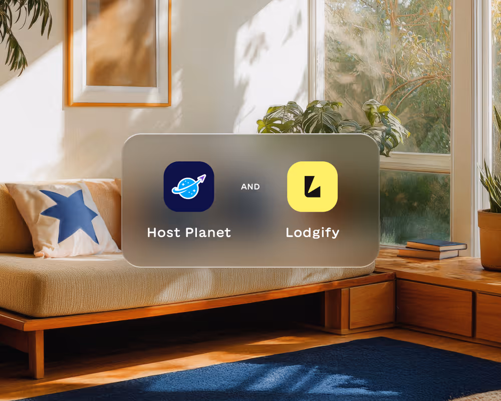 Living room with beige couch, star pillow, plants, large windows, and logos for Host Planet and Lodgify.