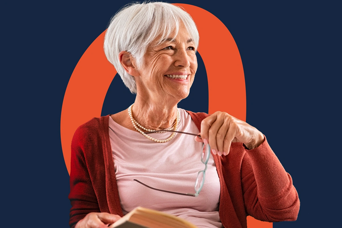 Femme âgée souriante tenant ses lunettes et un livre, avec un fond bleu et orange.