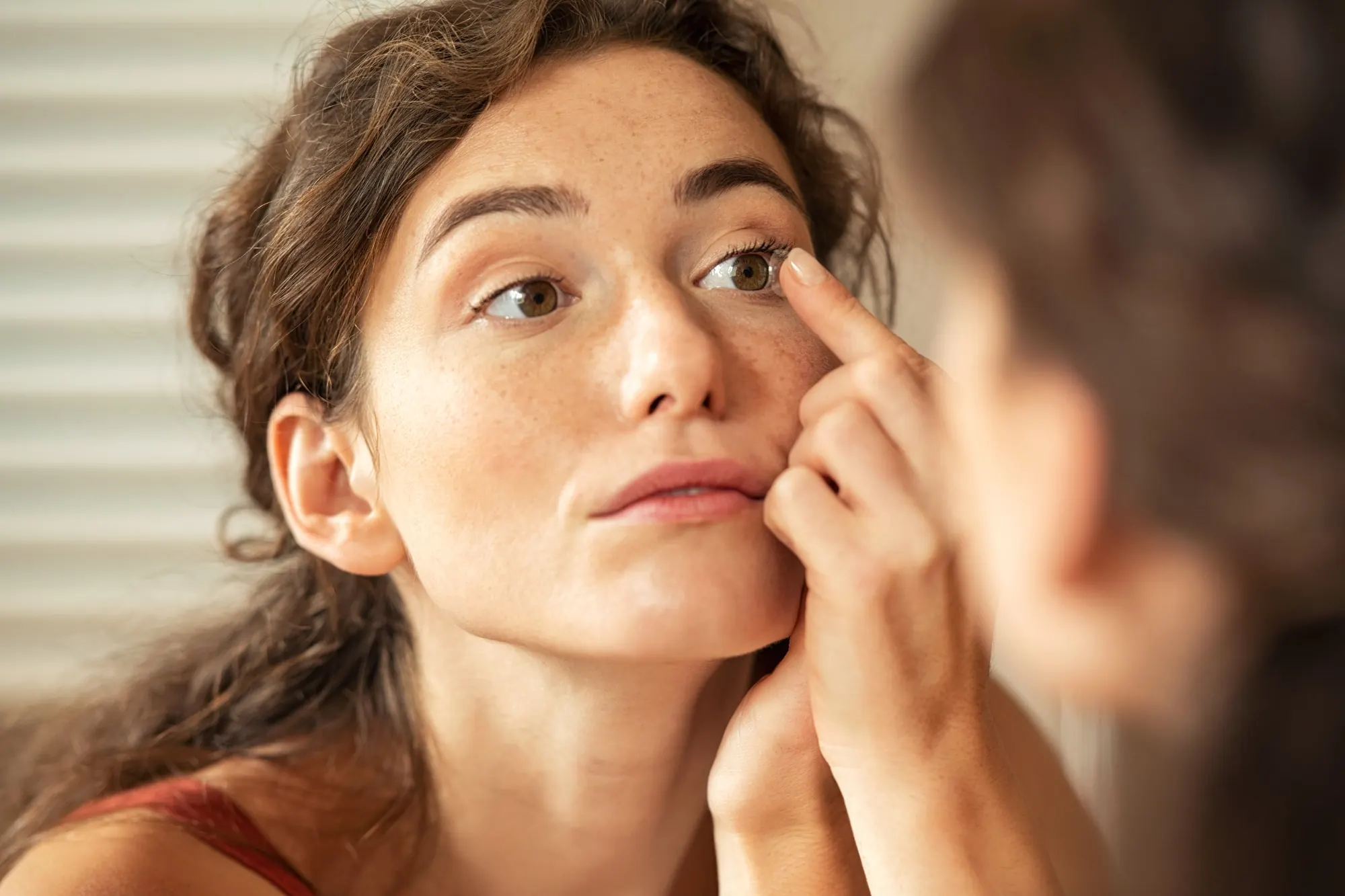 Woman inserting a contact lens into her eye