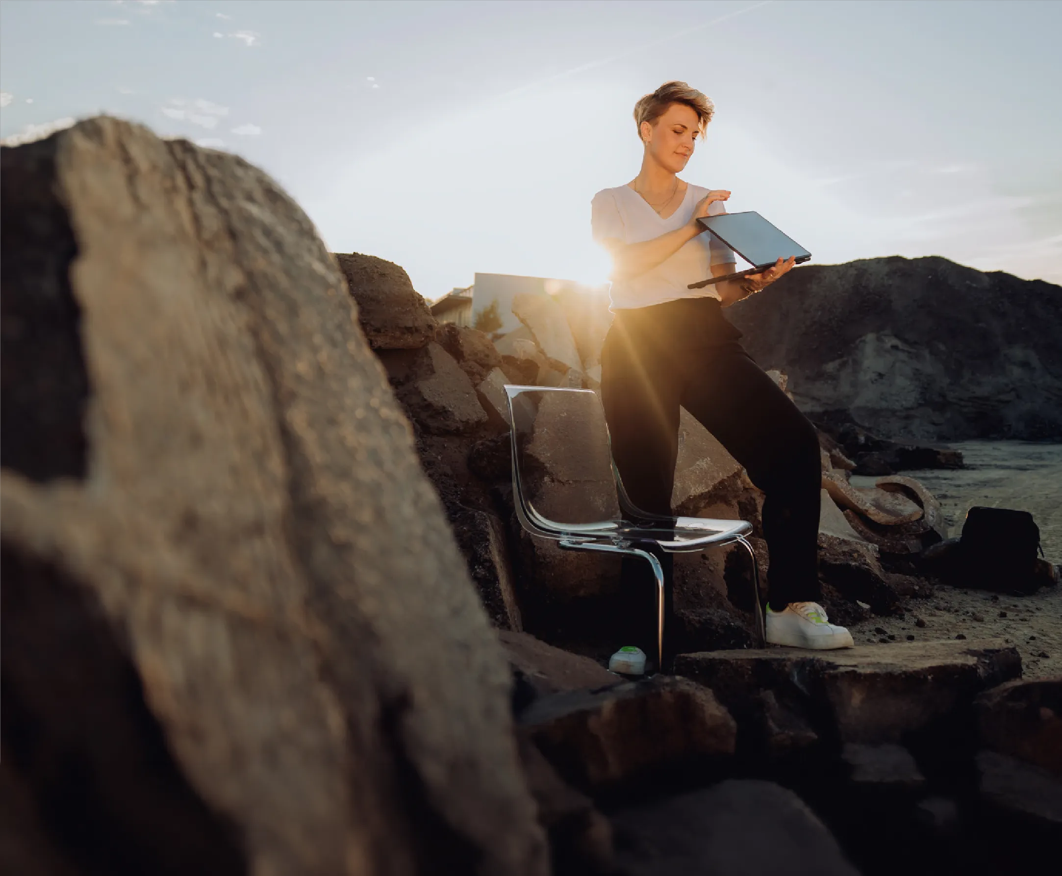 Tanja Kranz mit Laptop auf Felsen im Sonnenlicht