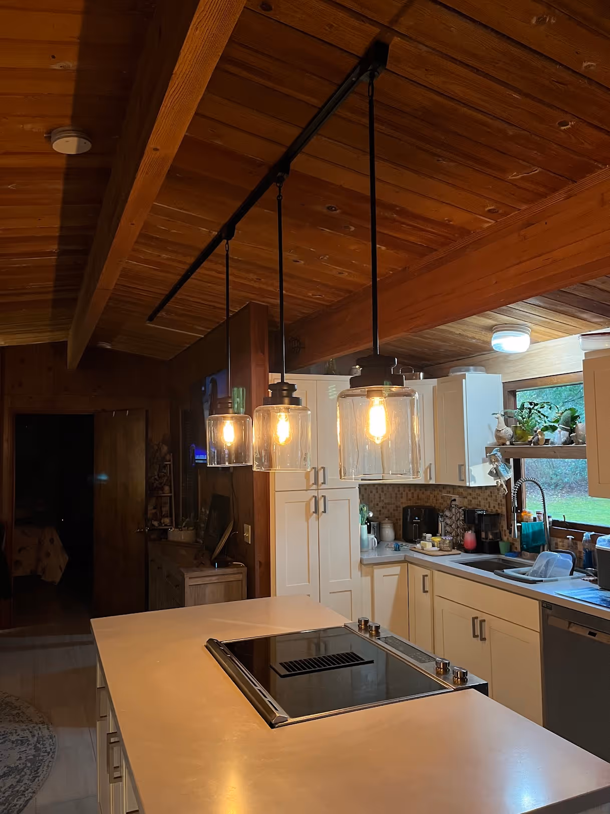 Warm overhead track lighting illuminating a clean kitchen countertop