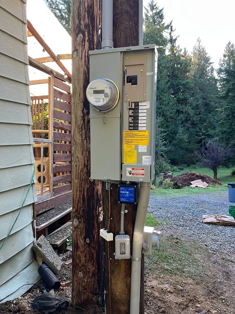 Outdoor electrical service post featuring an installed breaker panel and a round glass electric meter
