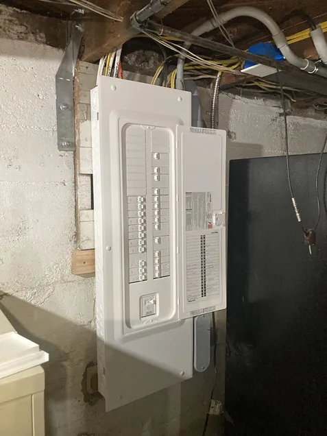 An electric panel mounted on a basement wall with complete switches