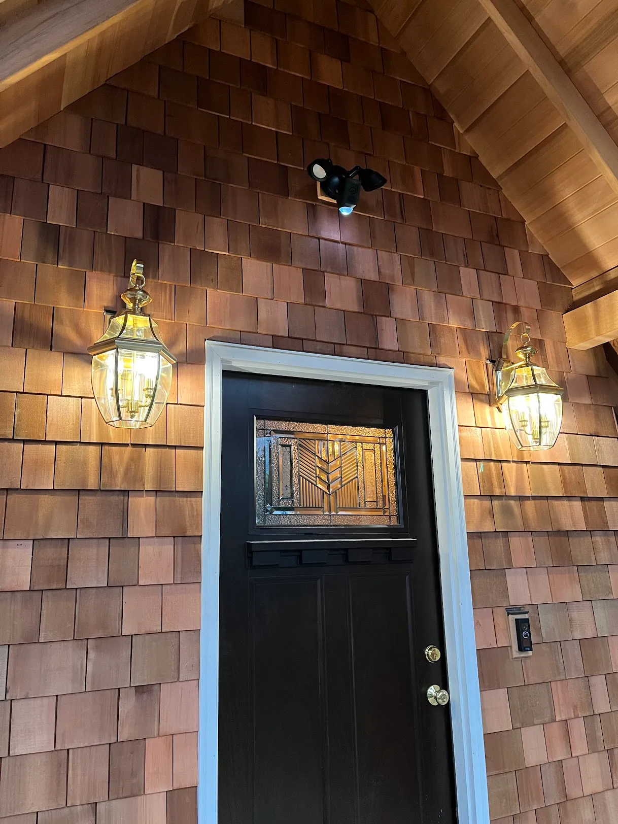 Front entry door updated with an exterior wall light installed on both sides