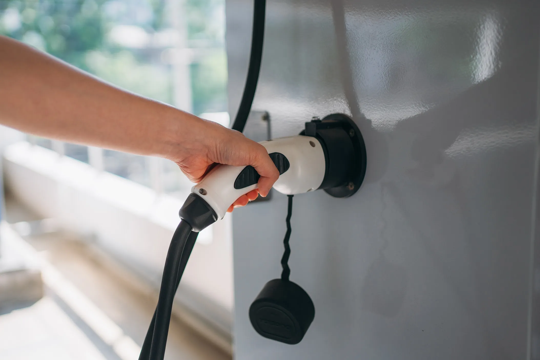 Close-up of an electric vehicle charging handle and cable