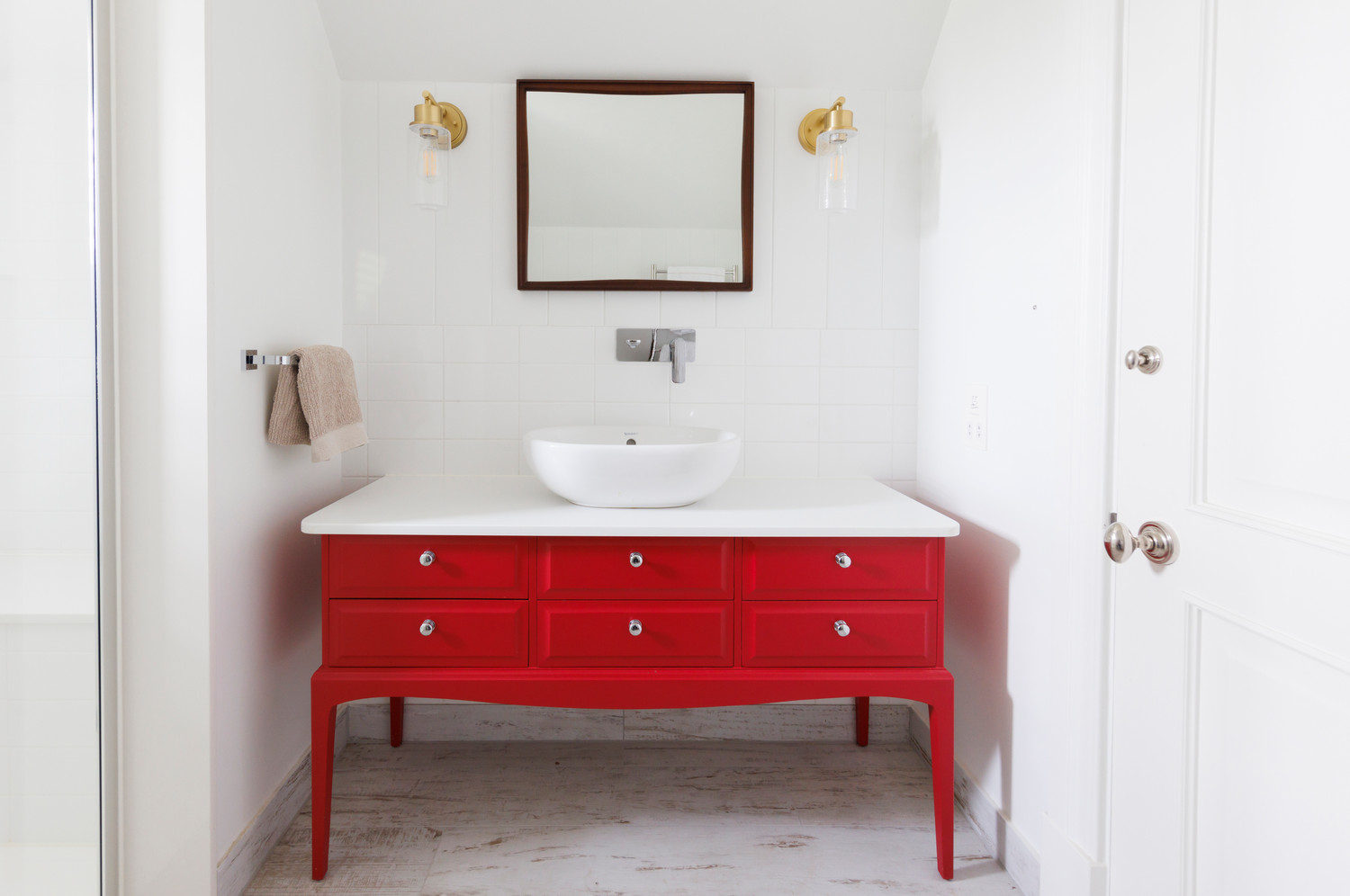 Bright coastal guest bedroom with red accents — a family and friends suite by Lorna Smith Interiors, Chichester