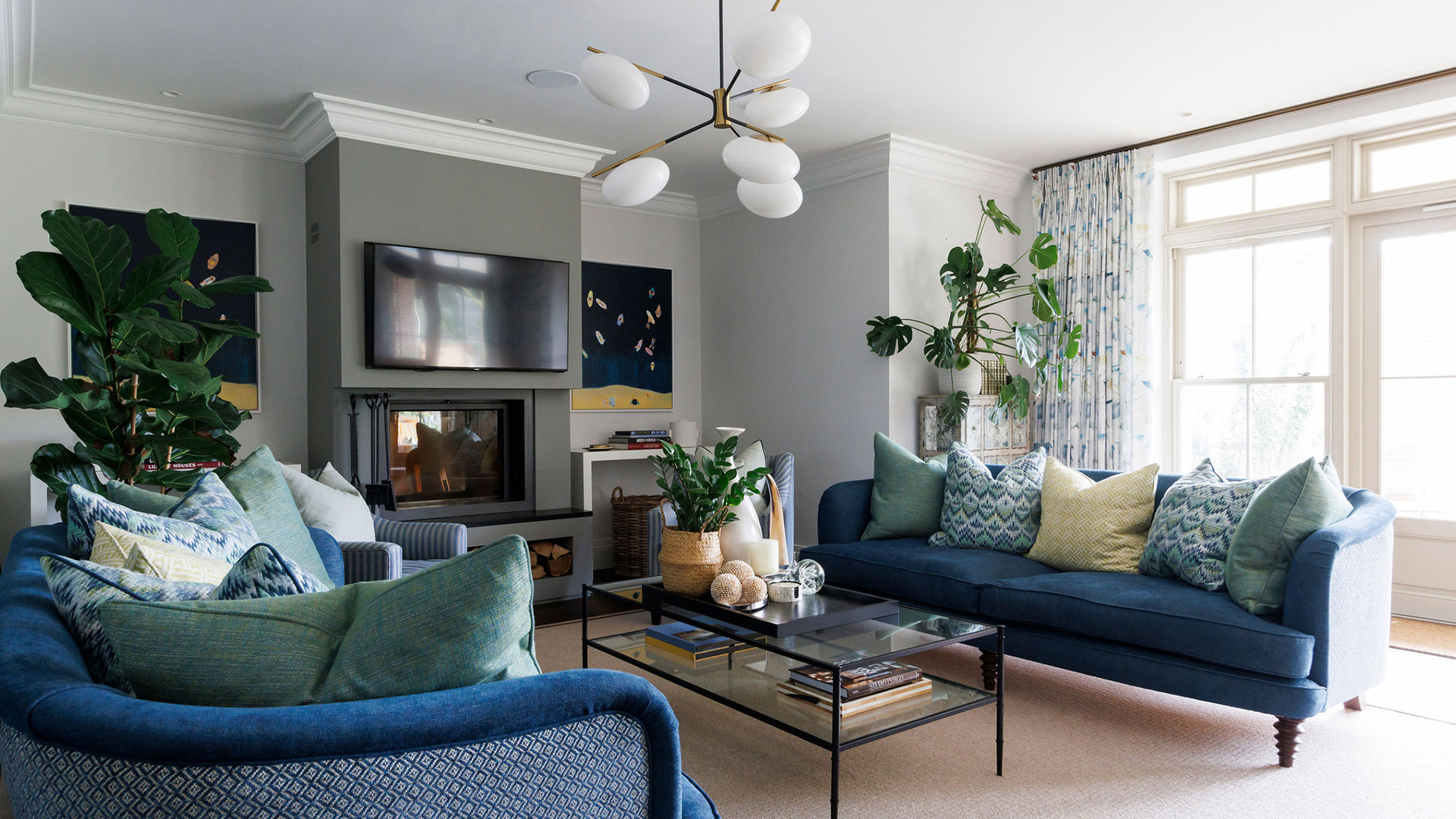 Coastal-inspired sitting room with navy sofas and layered cushions, designed by Lorna Smith Interiors