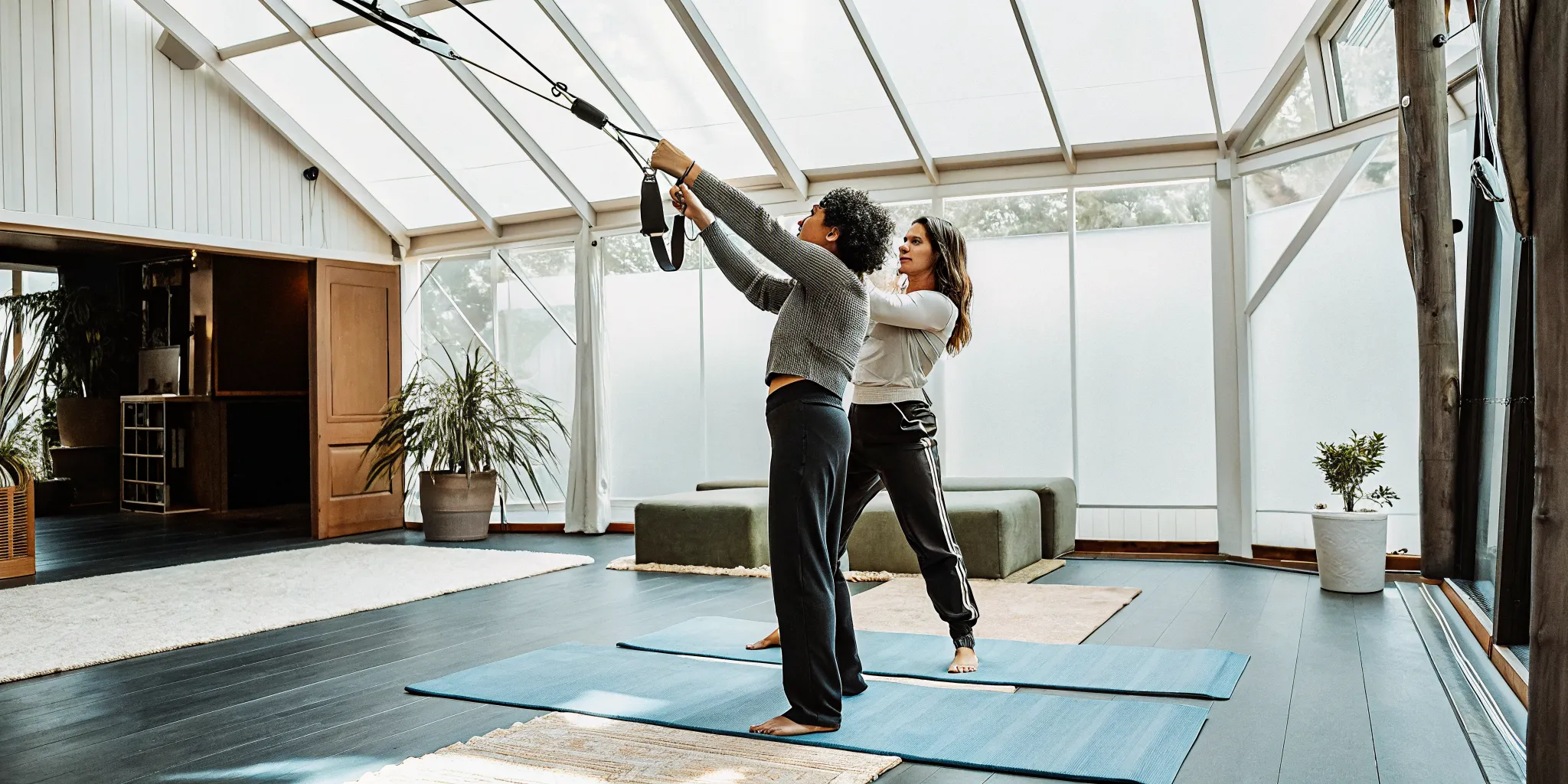 A fitness professional guiding a member through a mobility training routine to open up the shoulders and hips.