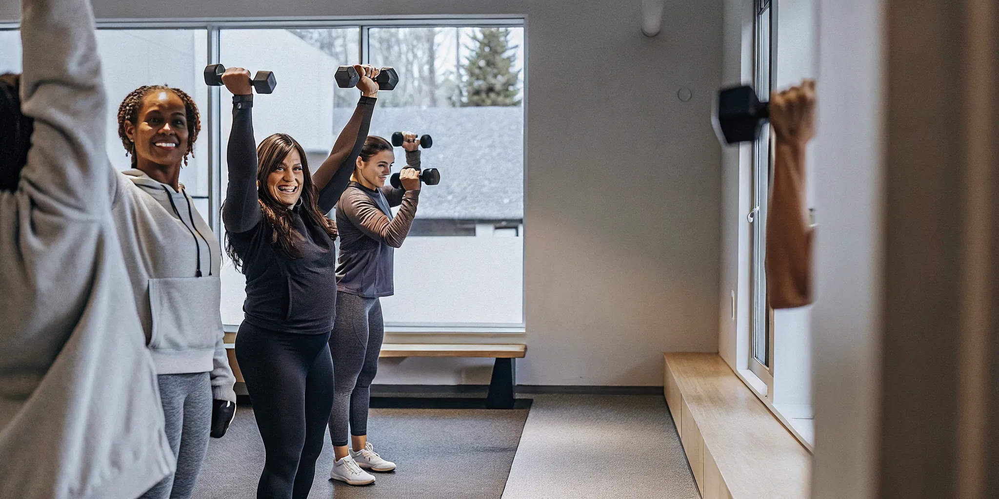 Women practising beginner strength training with a supportive coach