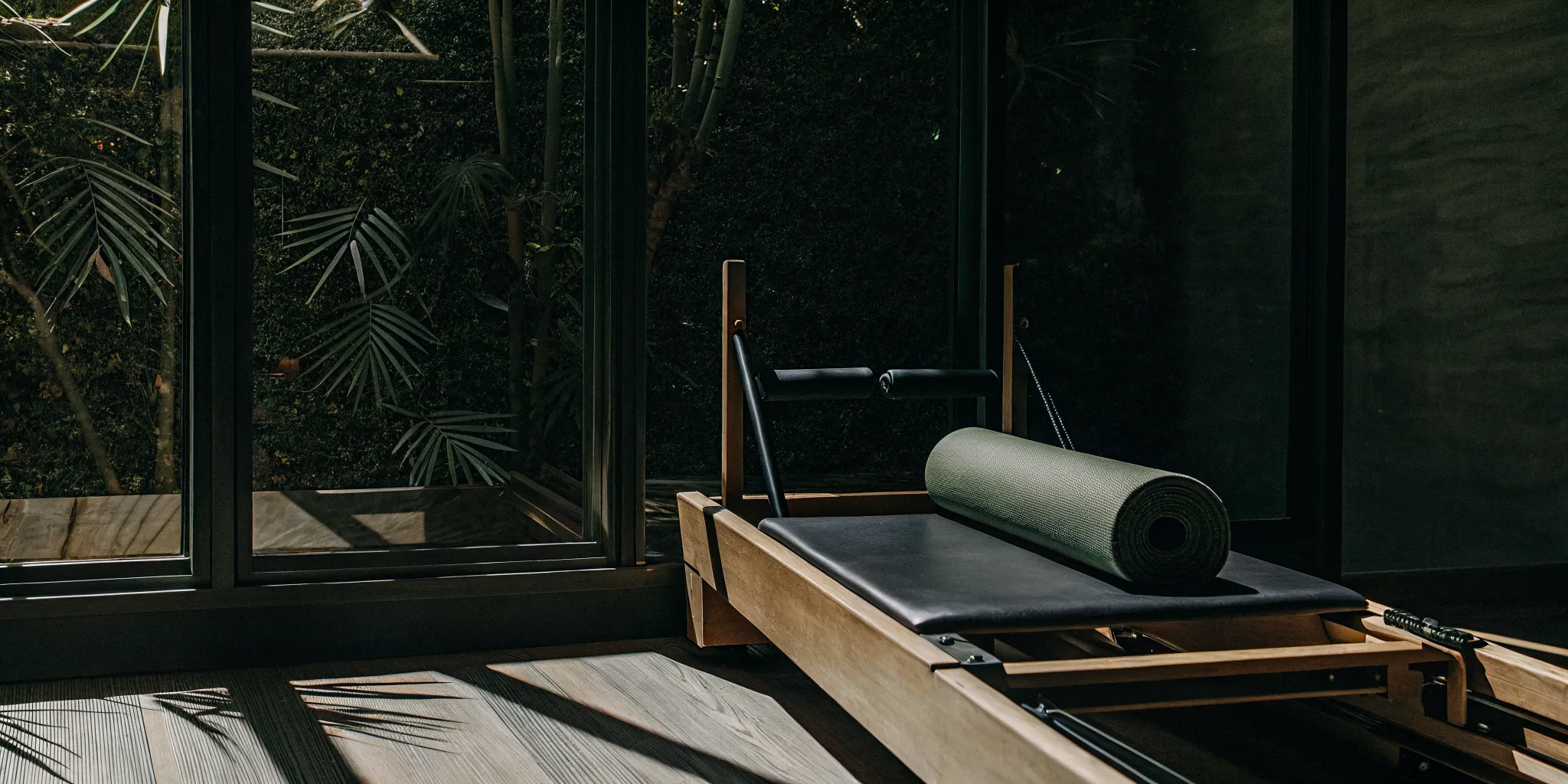 Reformer Pilates machine beside a mat for a reformer Pilates vs mat Pilates comparison