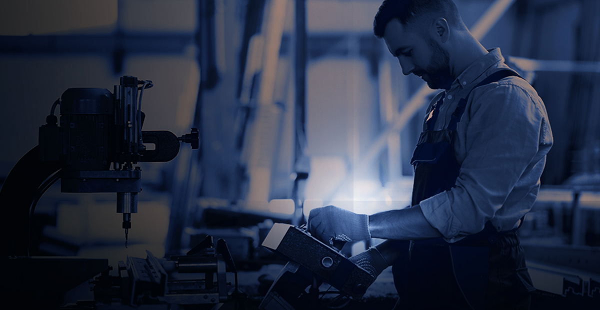 Industrial technician operating machinery in a smart manufacturing plant, representing AI-driven prescriptive maintenance, predictive analytics, and industrial equipment reliability solutions.