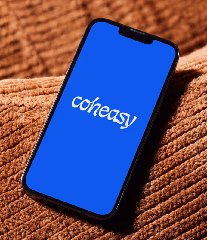Coheasy logo mobile mockup on a cell phone laying on a cushion.