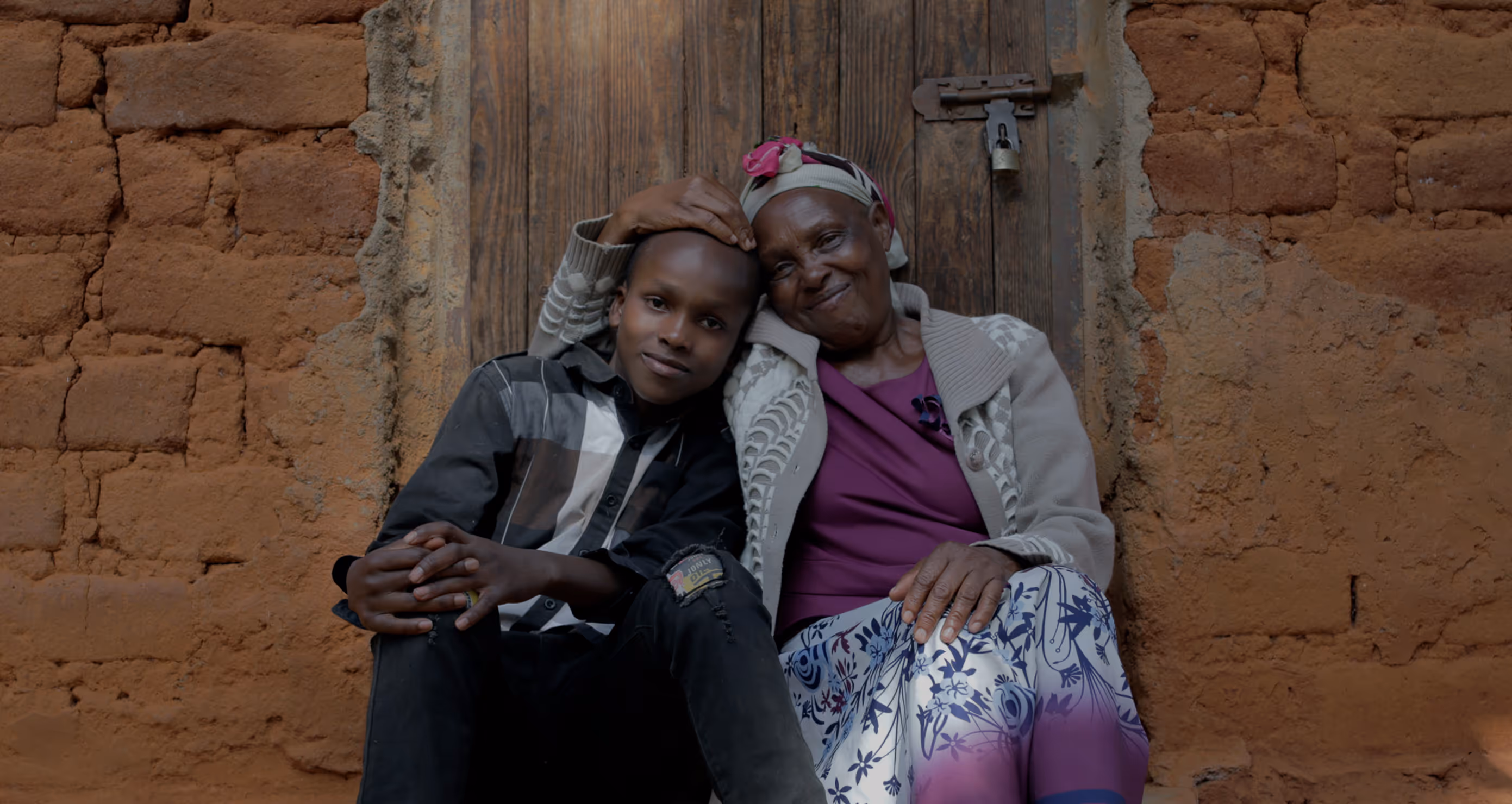 a mother and son in Kenya sitting on a stoop