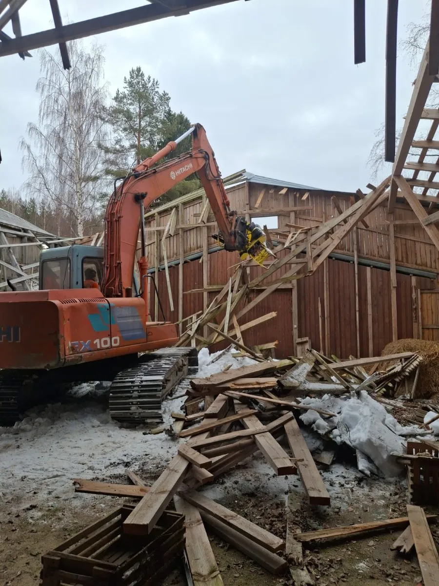 Rakennuksen purkutyöt kaivinkoneella