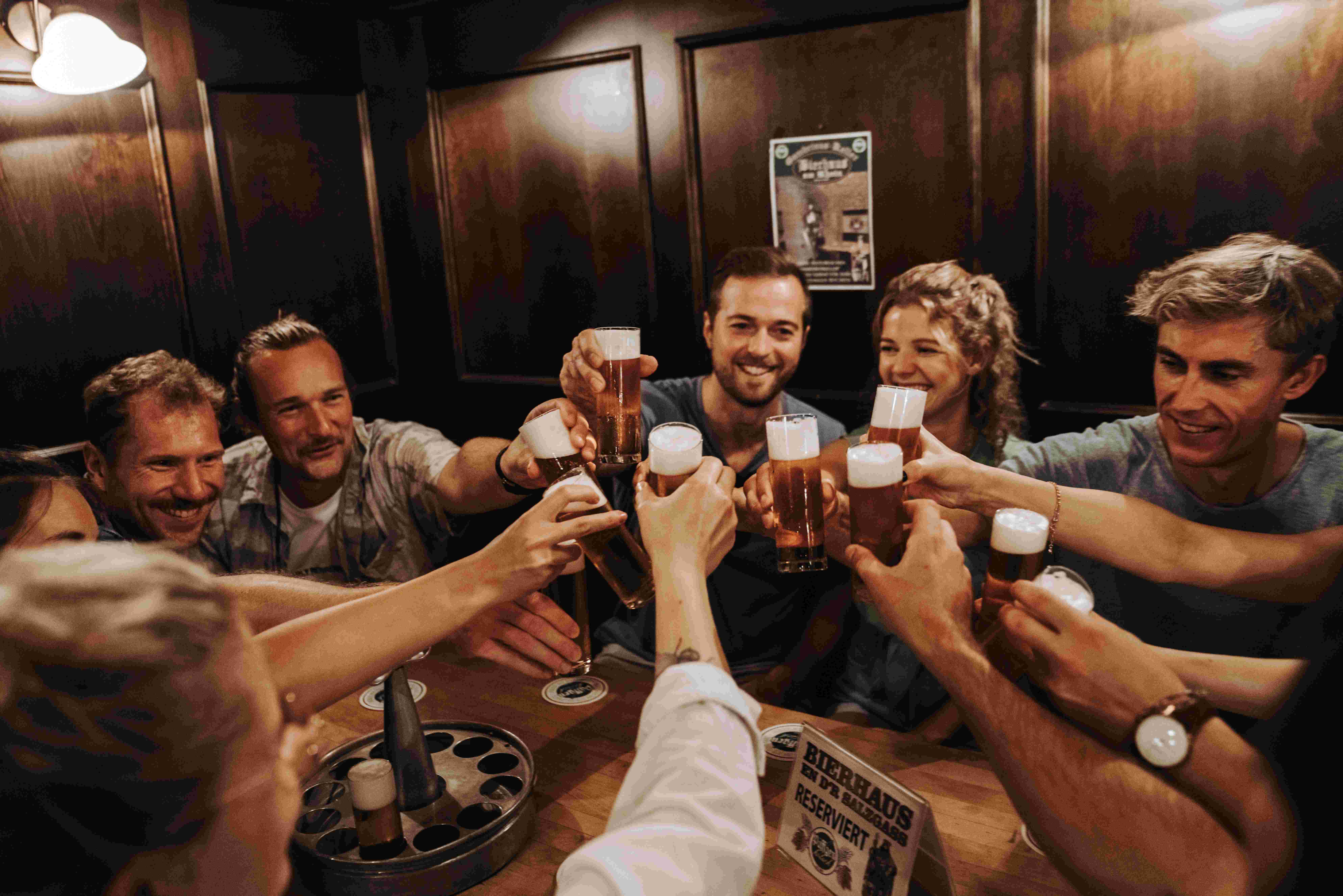 Gruppe stößt gemeinsam mit Kölsch-Gläsern in einem gemütlichen Kölner Brauhaus an