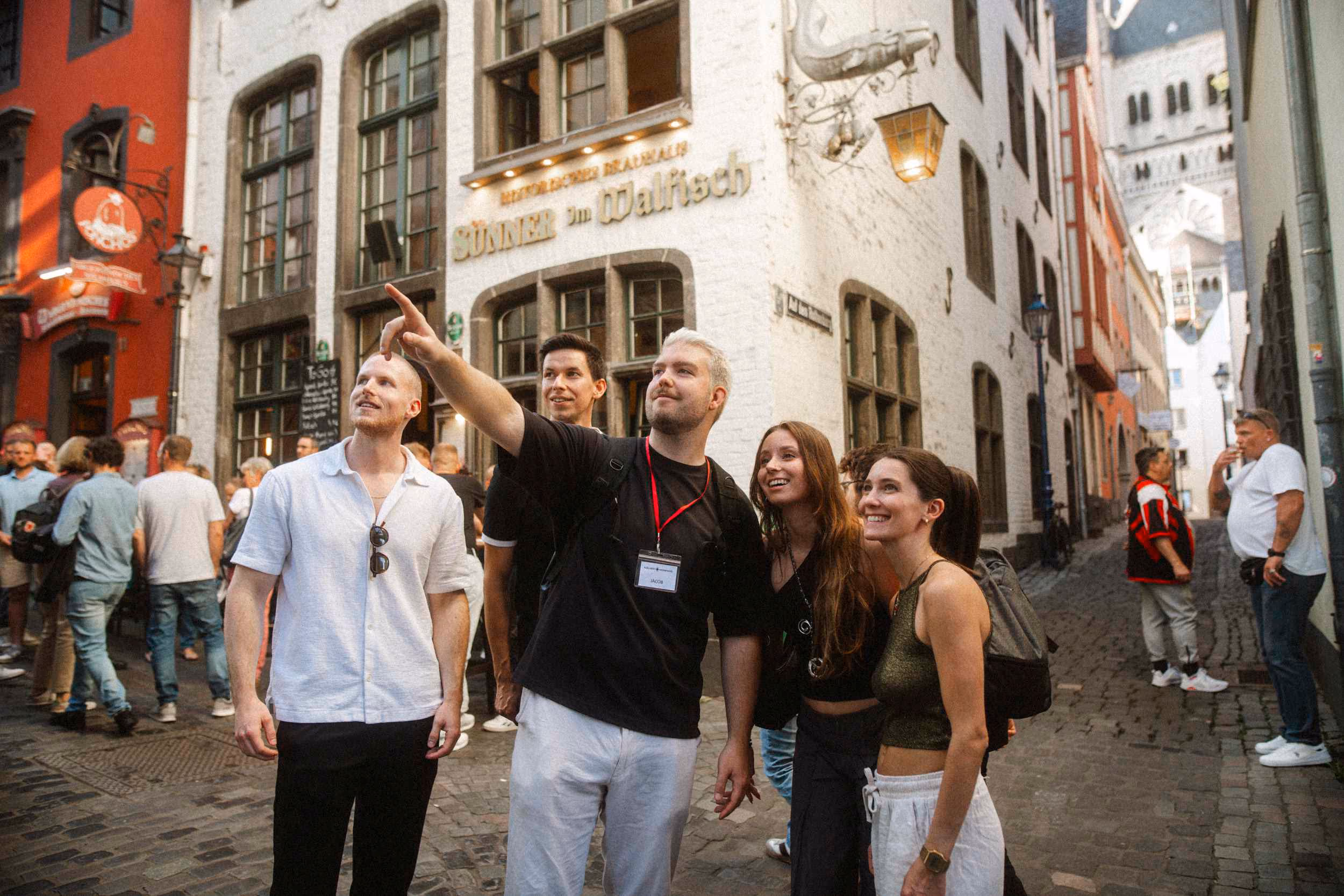 Kölner Kompass Tourguide zeigt Gästegruppe etwas in der Kölner Altstadt
