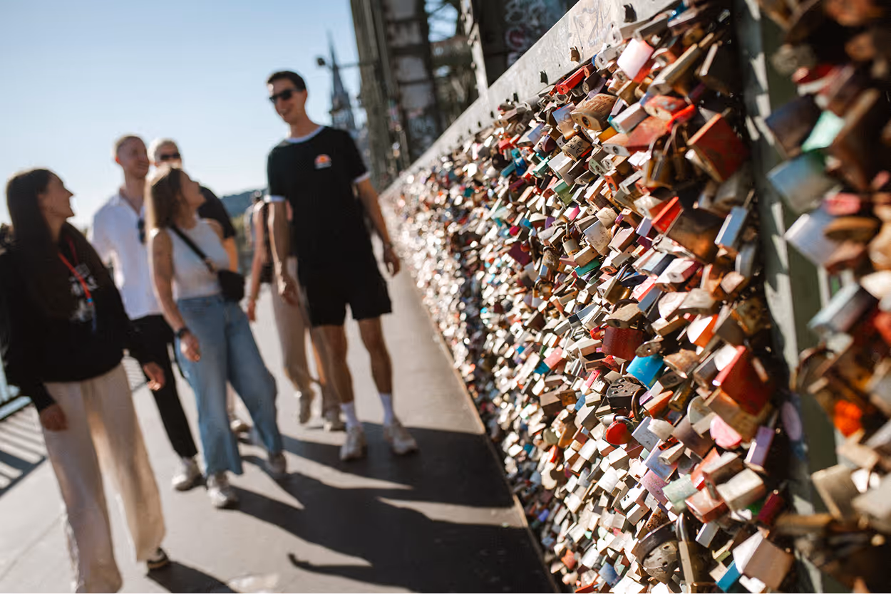 Kölner Kompass Tourguide geht mit Gästegruppe entlang der Liebesschlösser auf der Hohenzollernbrücke