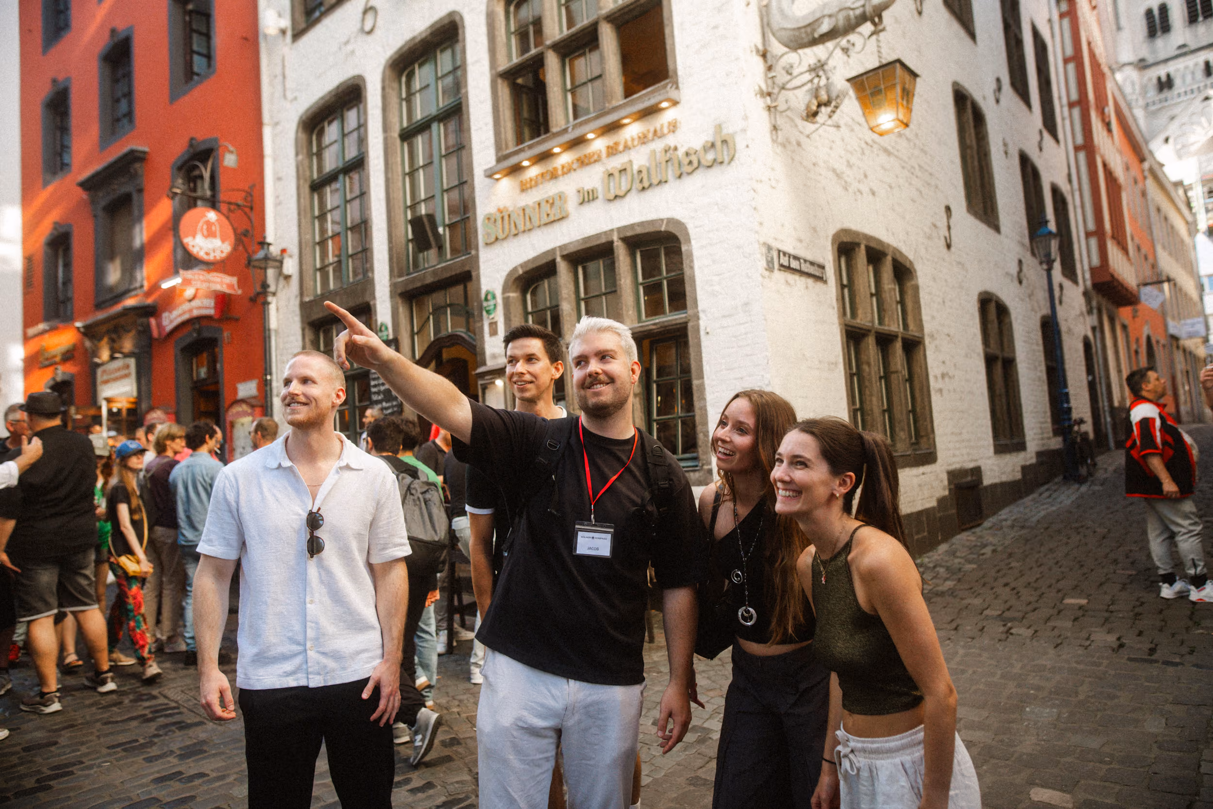 Tourguide zeigt einer kleinen Gruppe Sehenswürdigkeiten in der Kölner Altstadt