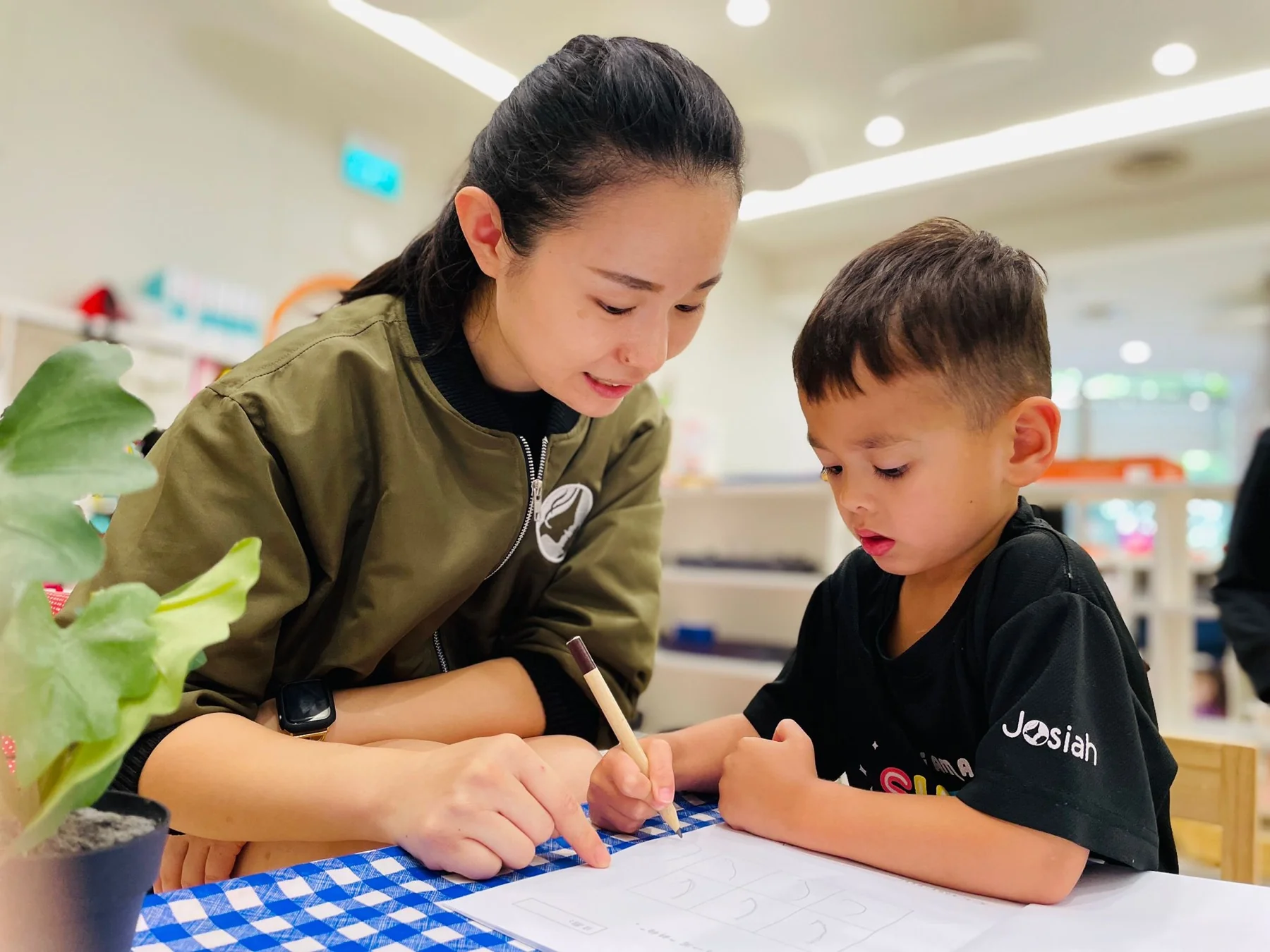 A Josiah teacher writes alongside a child during a self-directed activity.