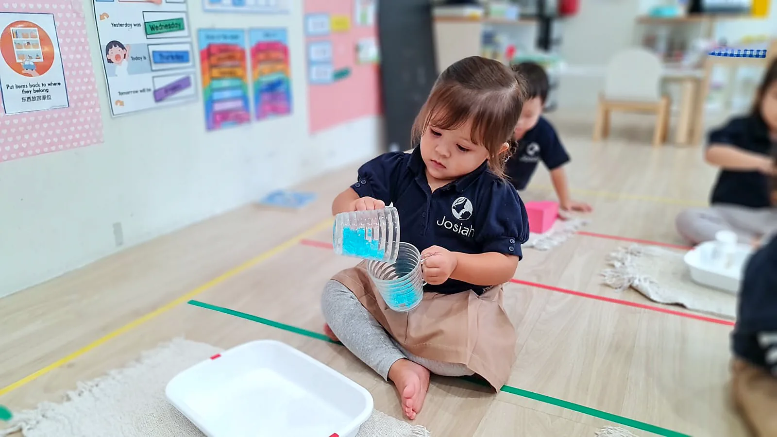 What a parent sees from the classroom doorway: a child absorbed in practical-life work.
