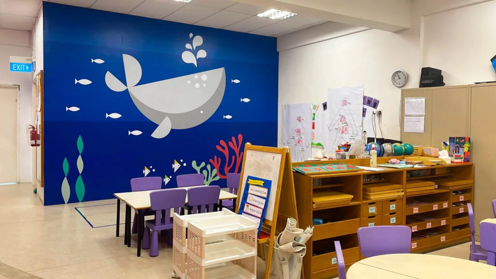 Inside Josiah Montessori Tampines Mart — a kindergarten classroom with whale mural.