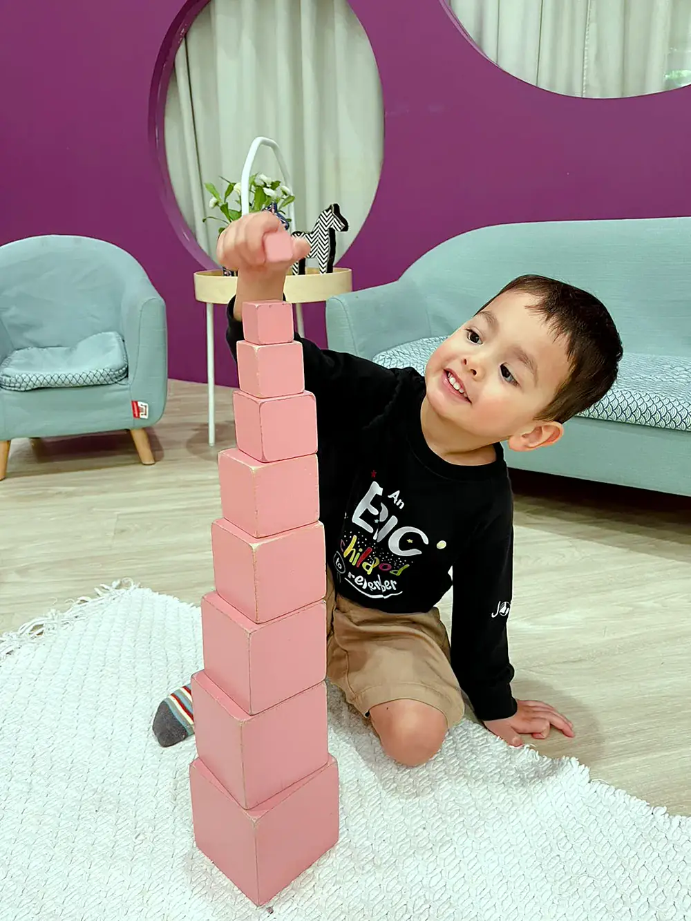 A Josiah child works at a Montessori pink-tower exercise.