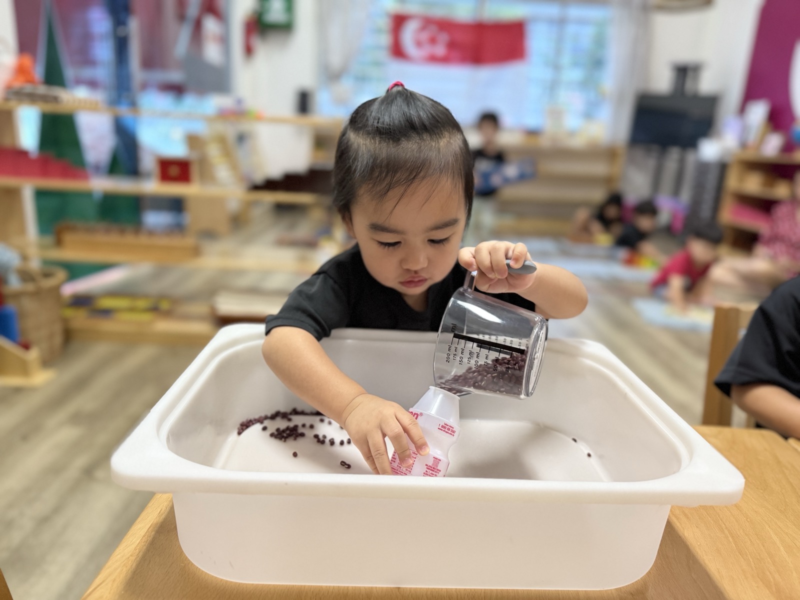 A toddler practising practical-life skills in Toddler Montessori