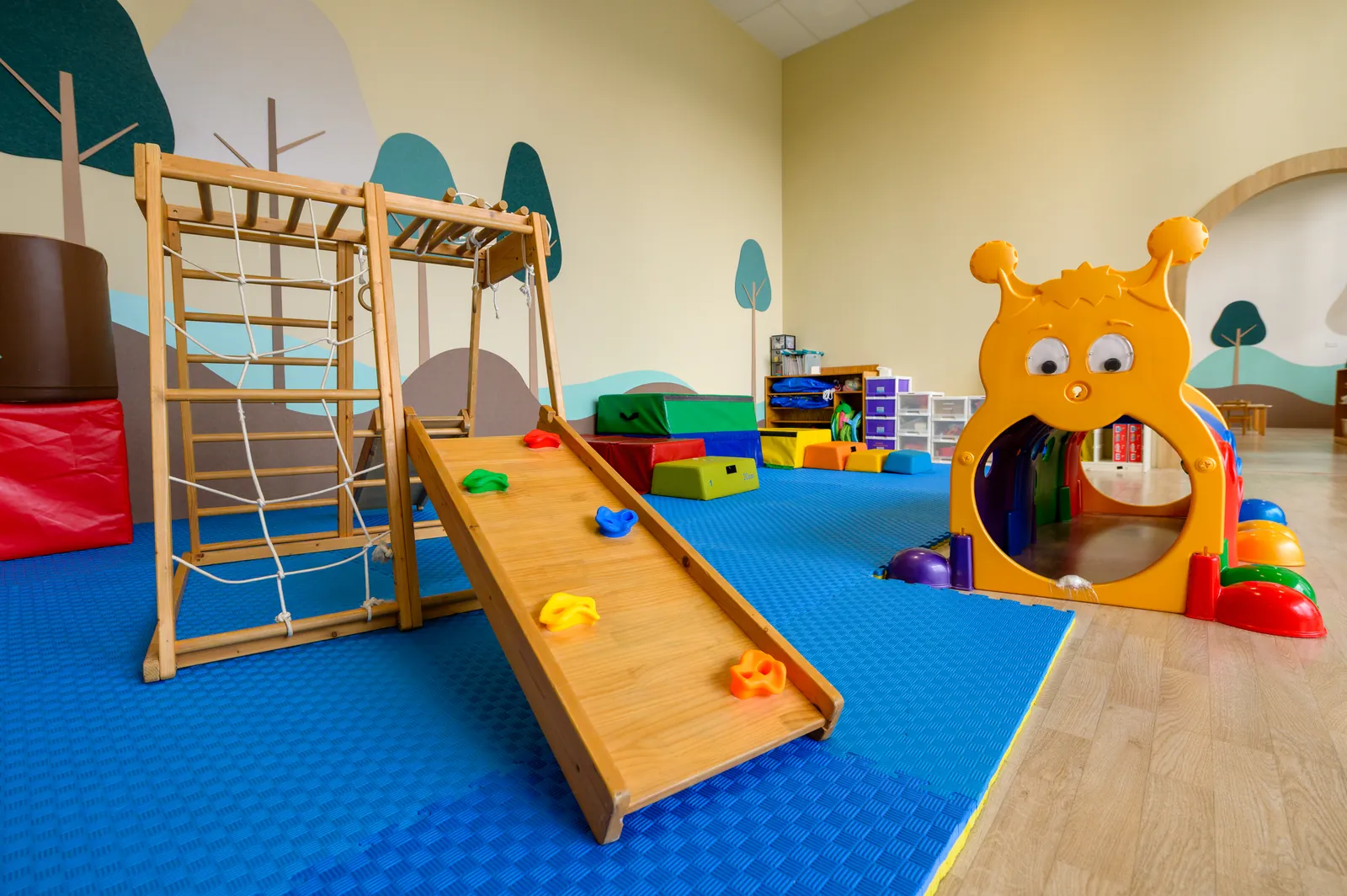 The indoor gross-motor area at Aperia, with climbing frame and slide.