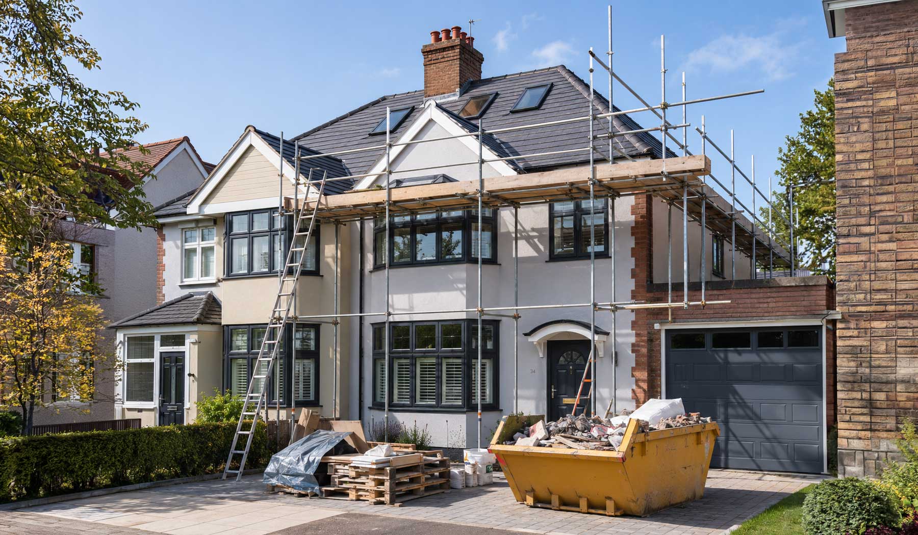 Modern property renovation with scaffolding, new grey tiled roof, contemporary windows, exterior rendering, and ongoing home improvement work on a UK detached house.