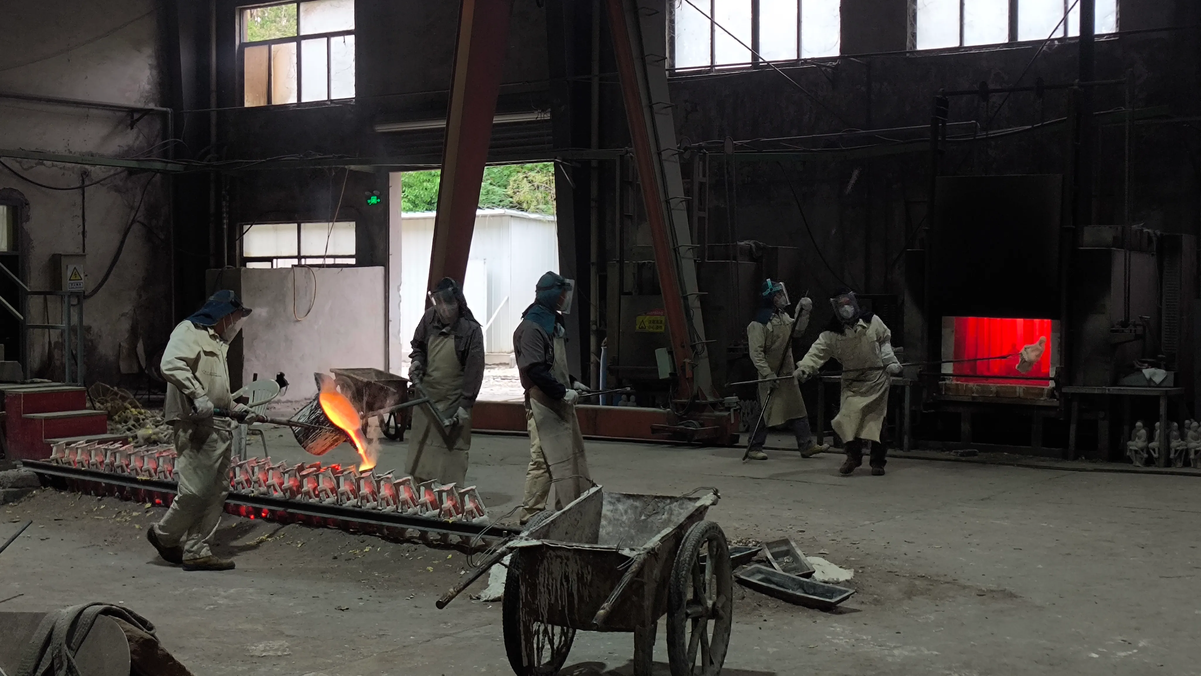 Artisans fabricating and refining a large metal sculpture in the workshop.